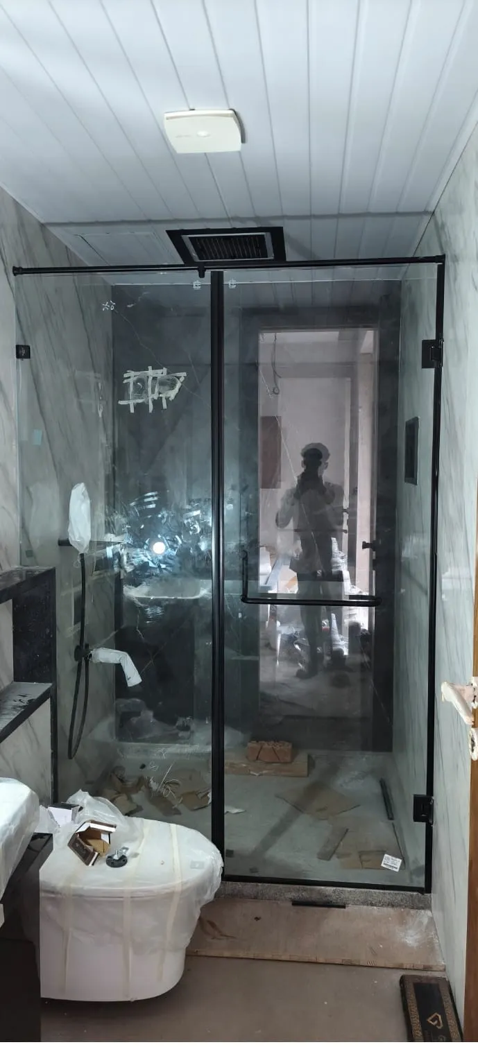 Frameless glass shower cubicle with gold fittings in luxury bathroom Bangalore
