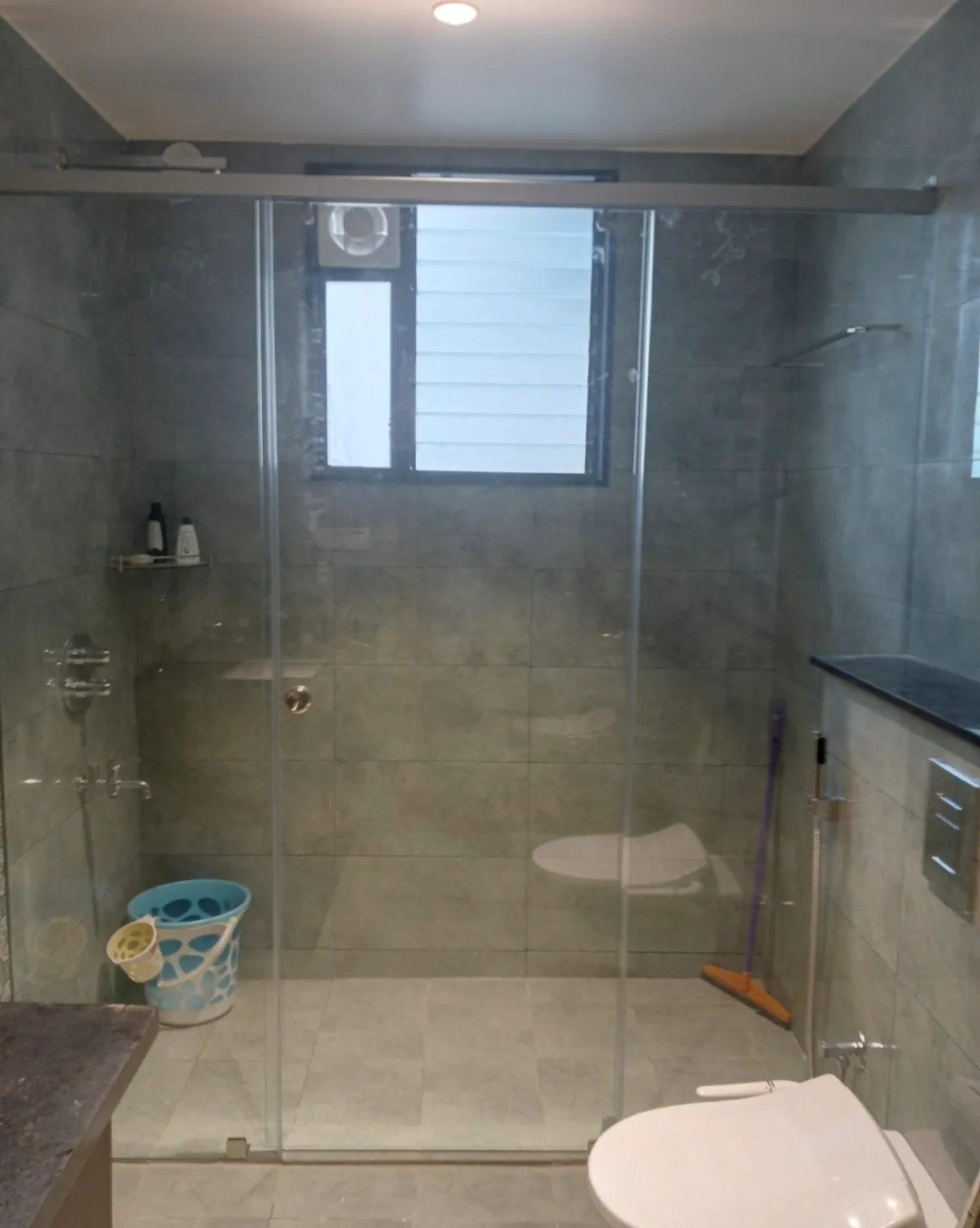 Frameless glass shower installation in Bangalore featuring sliding door and luxury gold hardware
