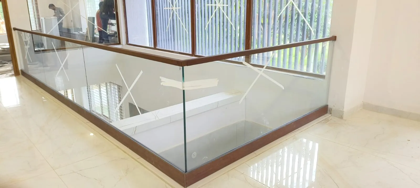 Frameless glass balcony railing with wooden handrail installation in Bangalore residence