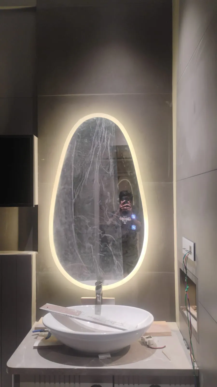 Asymmetric egg-shaped LED mirror with warm backlight in Bangalore bathroom