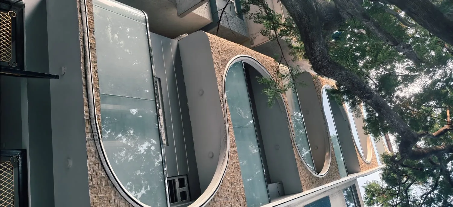 Curved glass balcony railings on multi-storey residential building Bangalore exterior